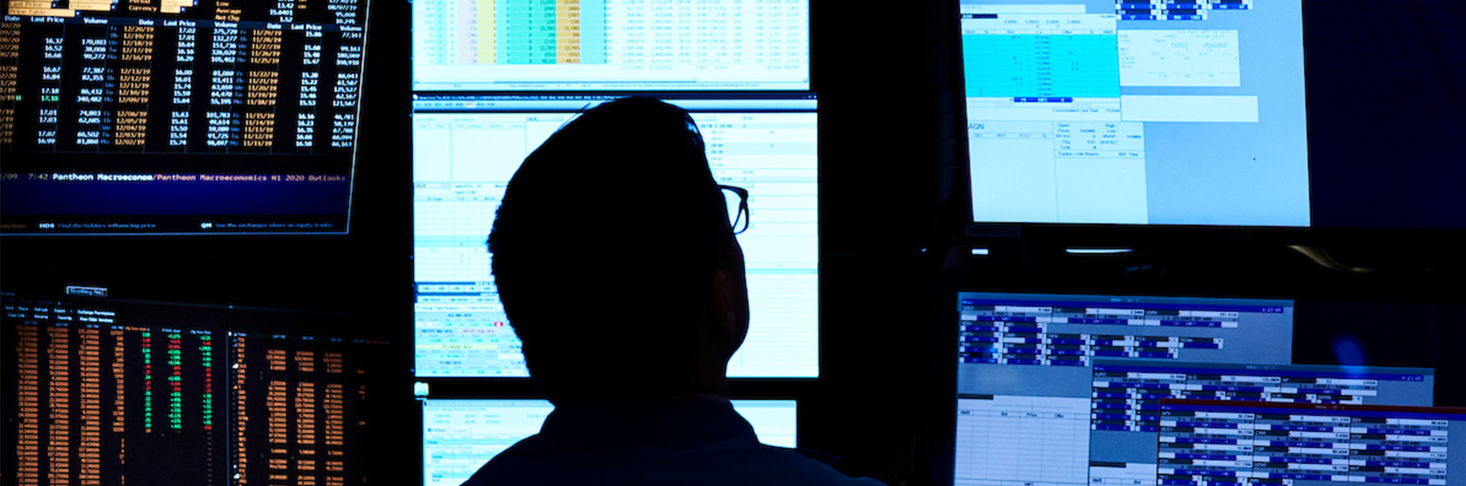 man sitting in front of a bunch of computers