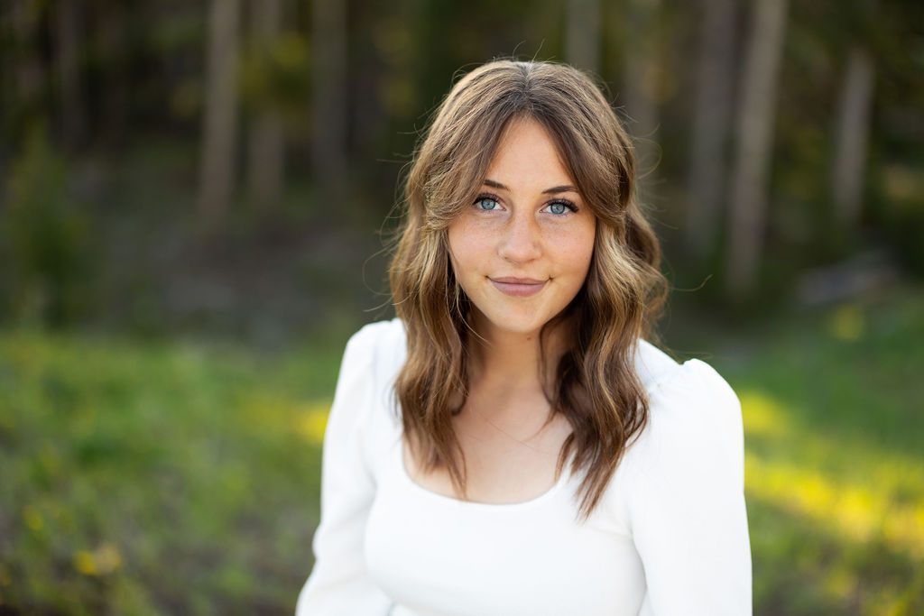 A girl with brown hair and a white top