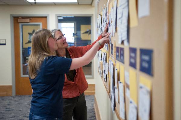 A picture of a Career Coach and a student looking at a job board