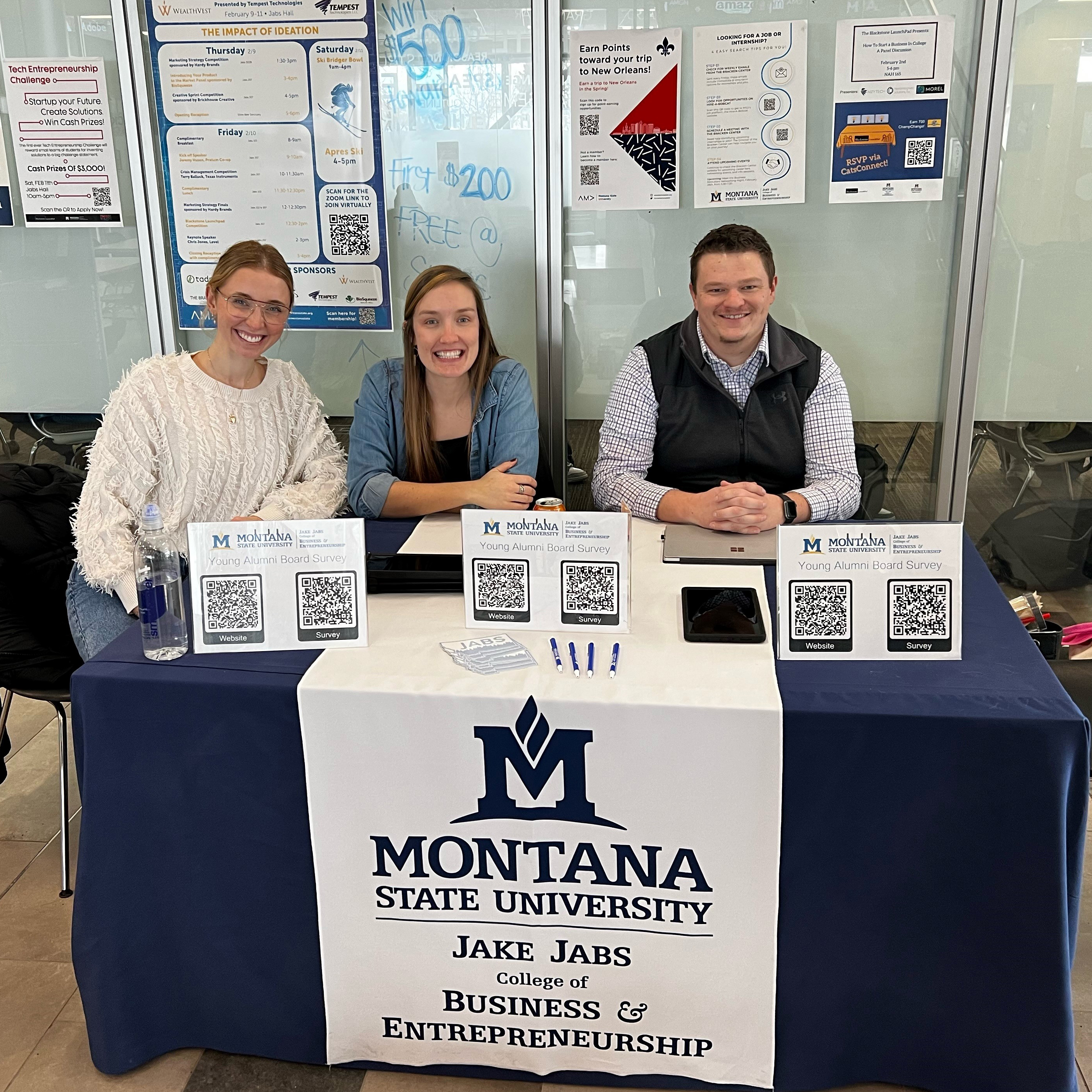 Three members of the Jabs Young Alumni Board sit at a table in Jabs Hall