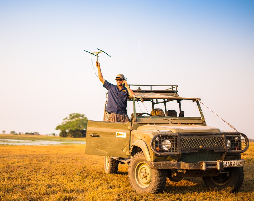 Ben Goodheart standing on a truck with a radio antenna above his head