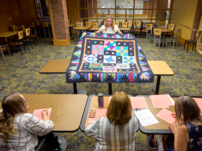 4-H member showing off her quilt in a state contest