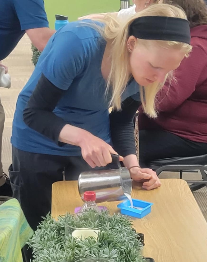 Woman pours soap into a container on a table