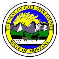 The county seal is round with depictions of moutains, a field, and a horse-drawn cart inside the text "The seal of Gallatin County" and "The State of Montana"