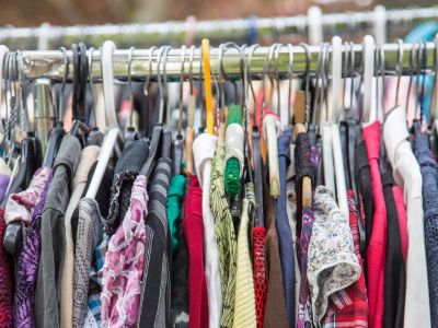 An array of shirts in different colors and styles hang on a clothing rack.
