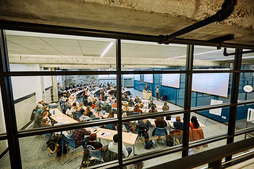 Students and instructor in classroom as seen from outside a window