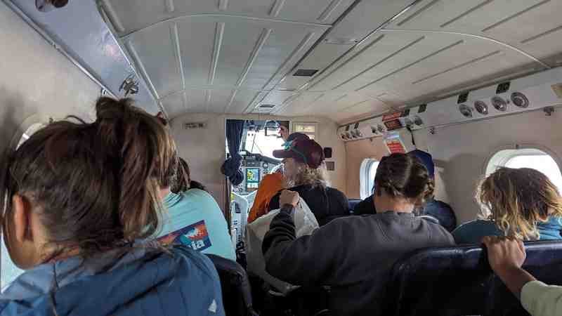 The group is pictured inside a plane in flight.