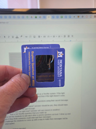 photo showing two polarizers held perpendicularly to each other in front of a computer screen with no light passing through.